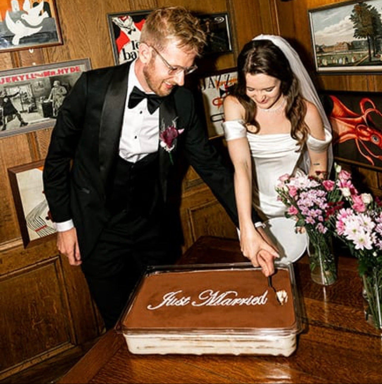 Bride and groom cutting a personalised luxury Italian tiramisu dessert at their wedding reception in the UK.